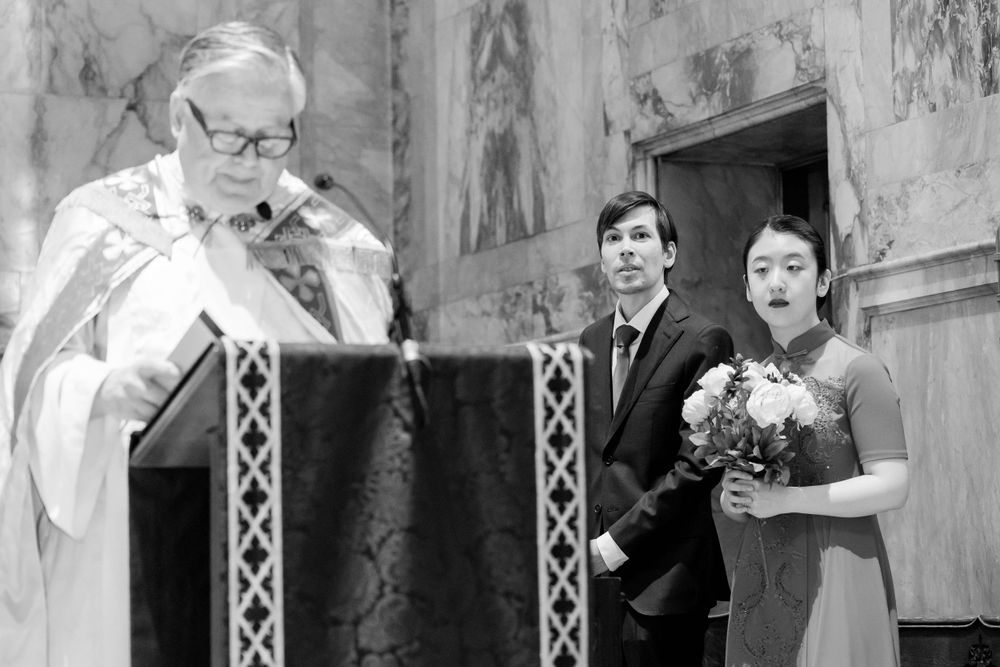 Black and white photo of religious ceremony in historic church interior.