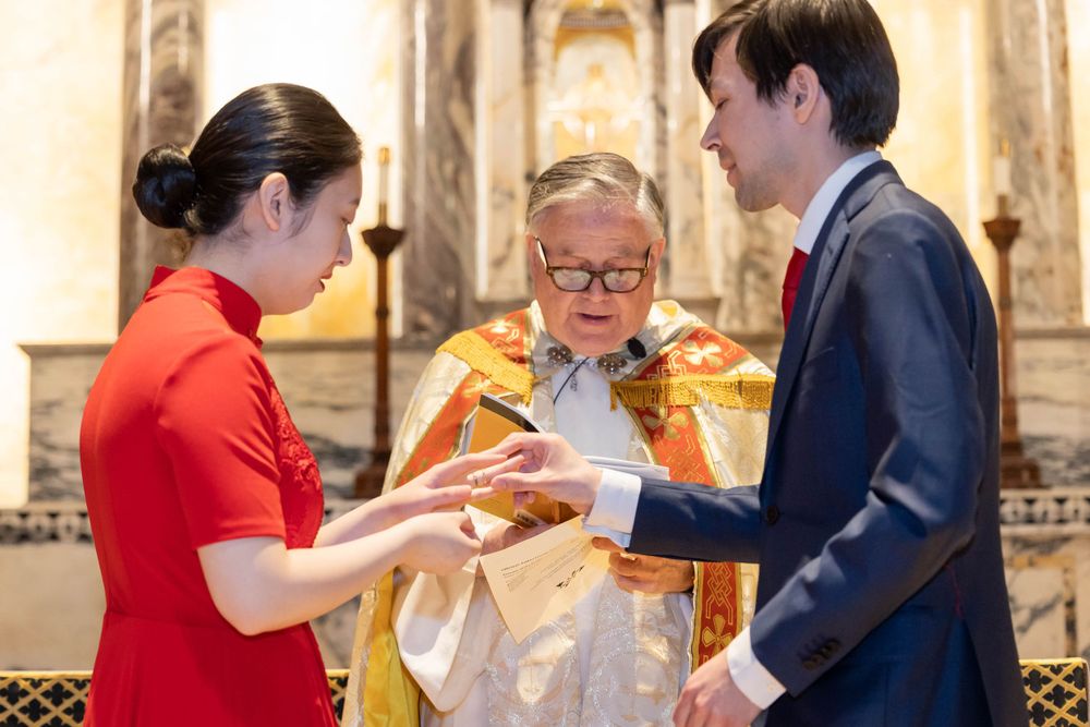 Religious ceremony with participants exchanging items at altar.