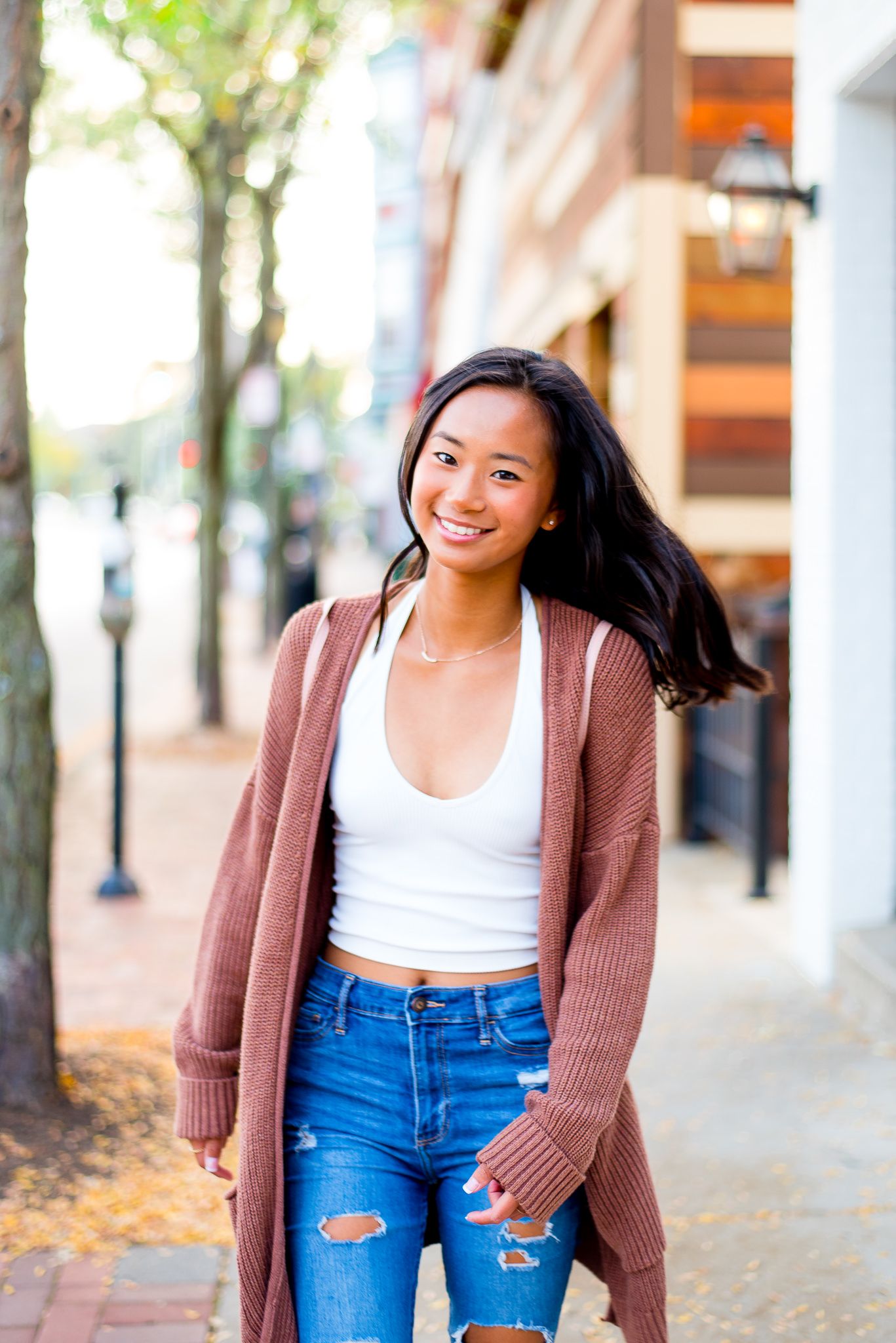 high school senior girl walking along sidewalk in Cincinnati