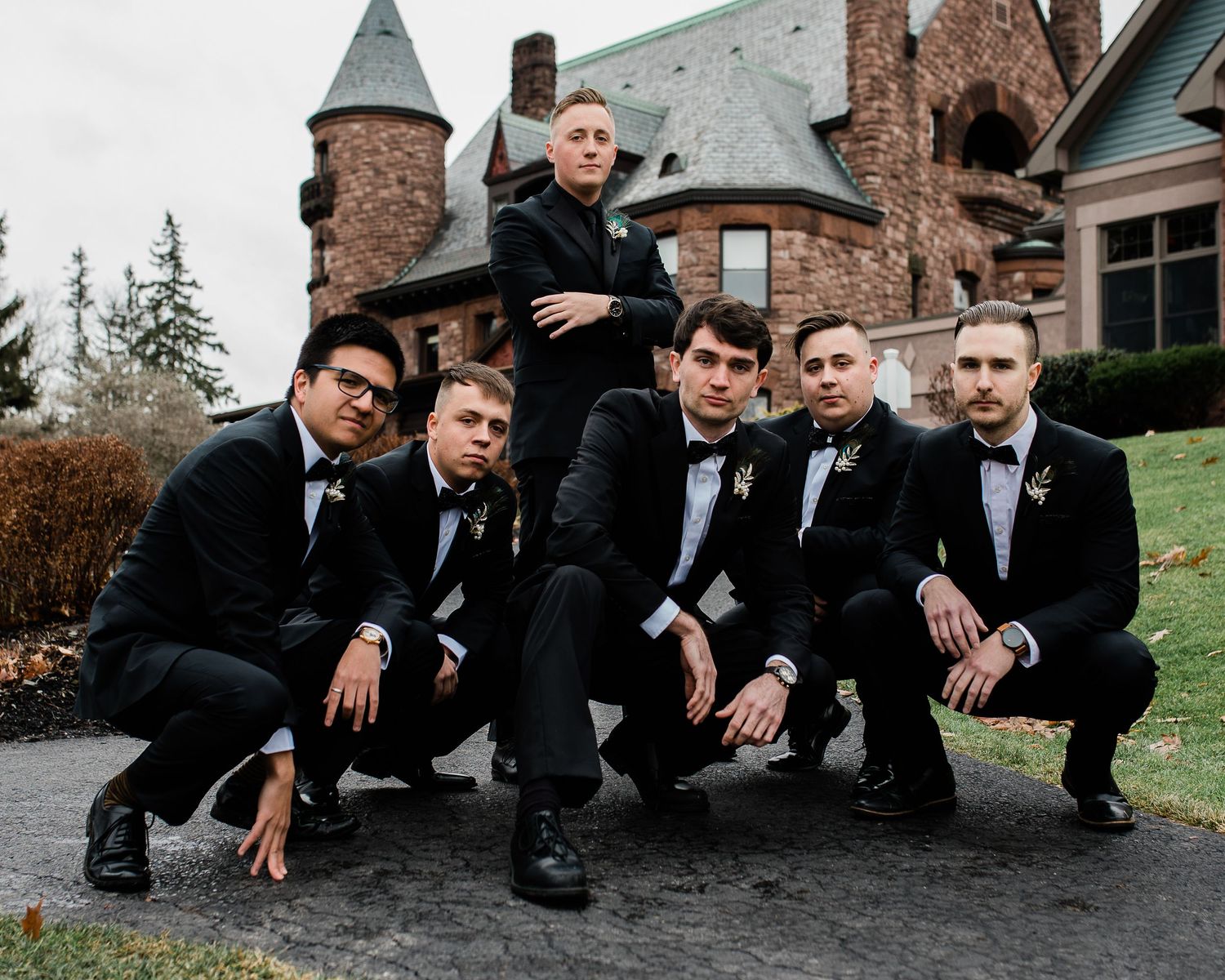 A group of groomsmen strike a pose in front of the Bellhurst Castle.