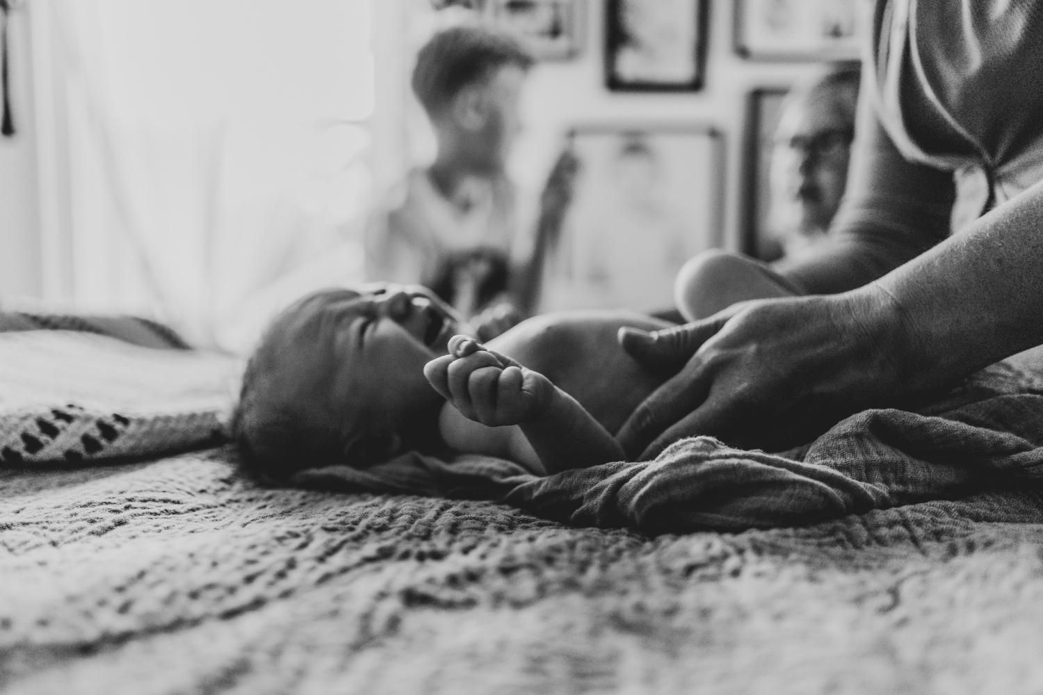 mom comforting a newborn baby crying