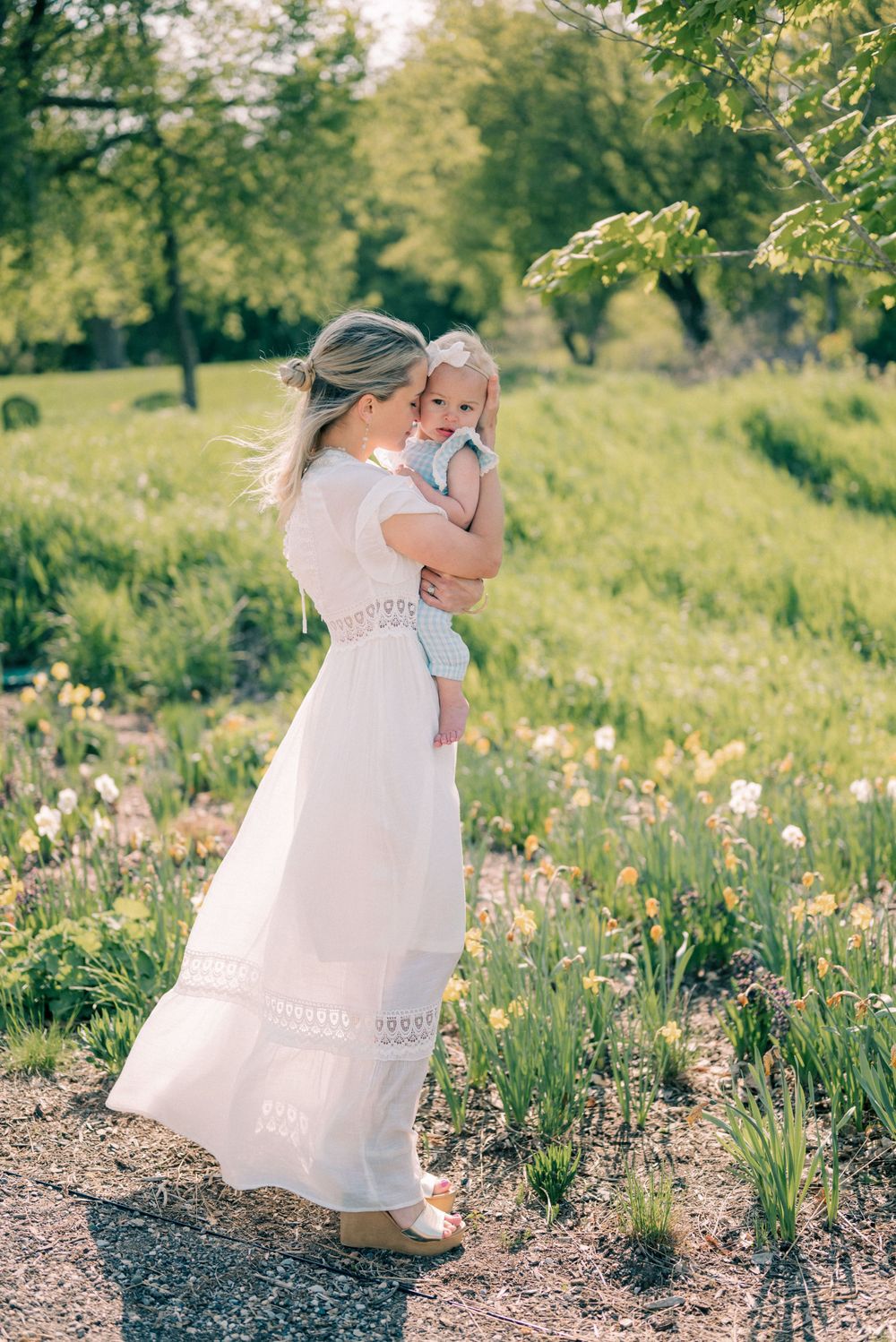 A sweet moment captured in a spring garden with white dress among blooming flowers.