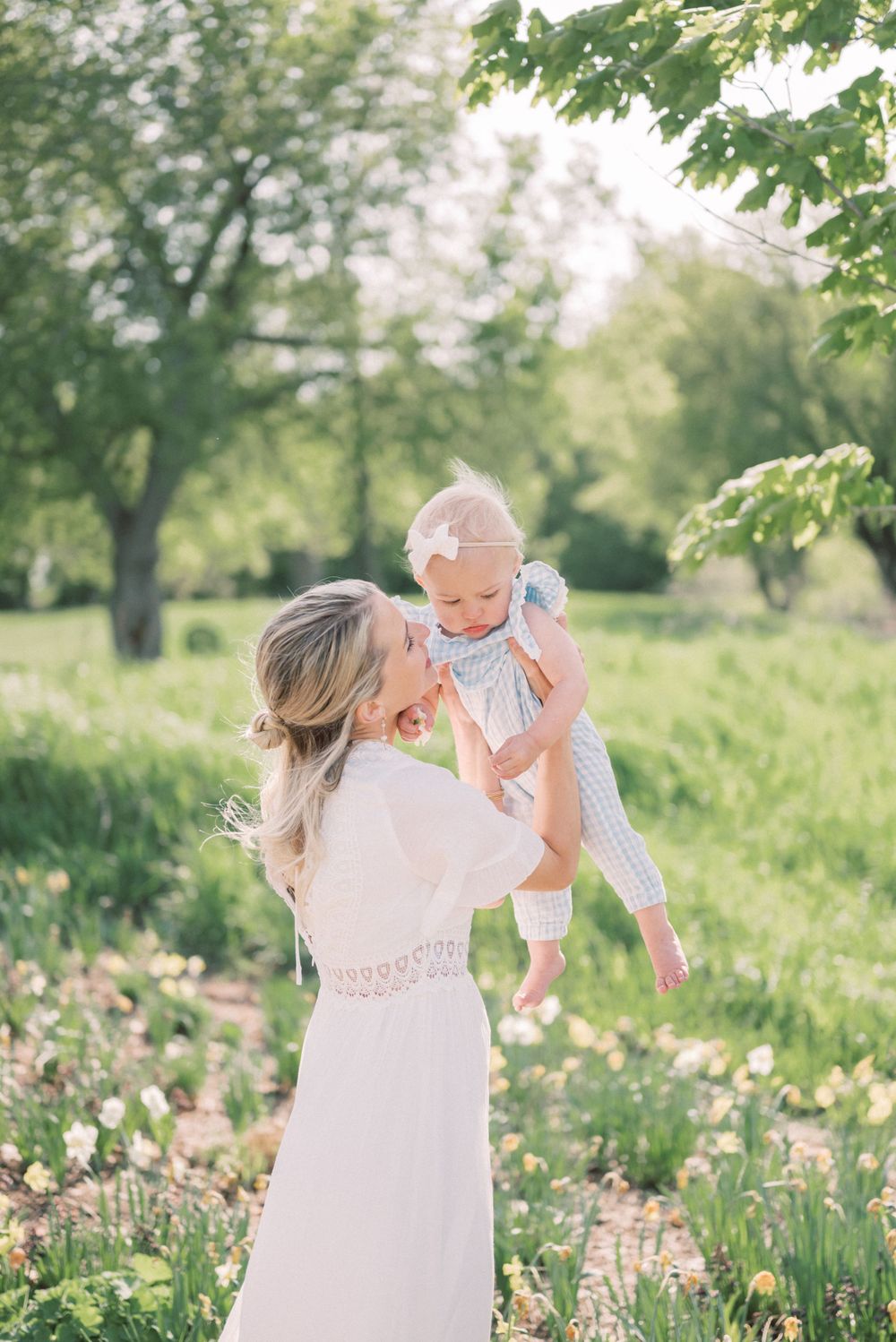 A joyful outdoor portrait among blooming spring flowers and lush greenery.