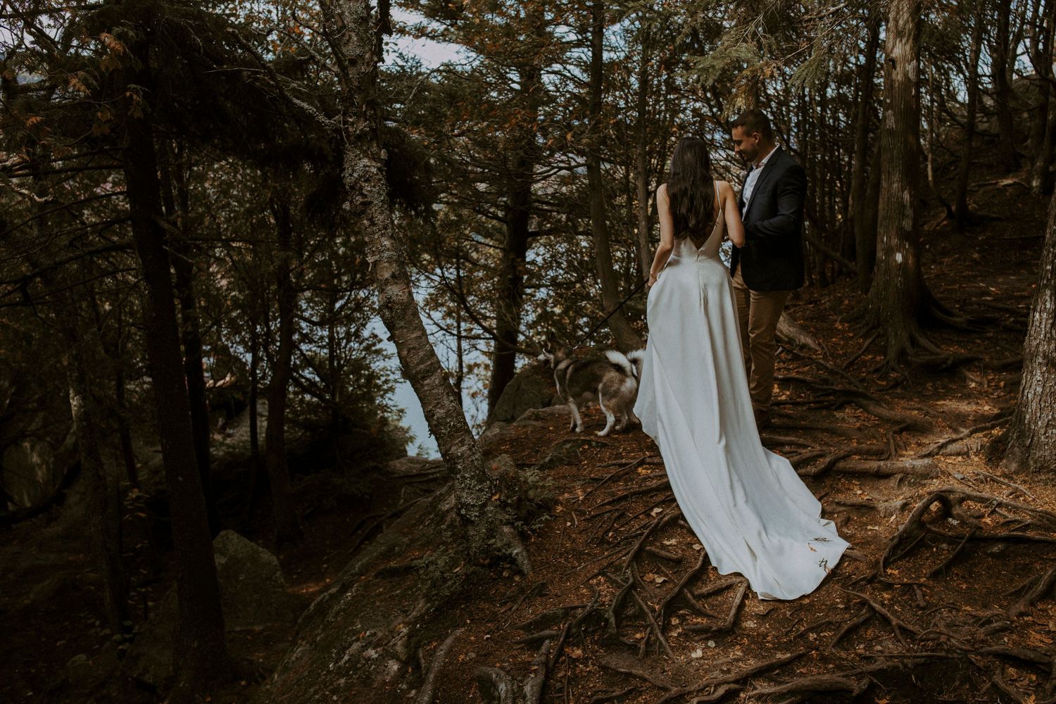 Les mariés marchant dans la fôret pour leur elopement avec leurs deux pomski