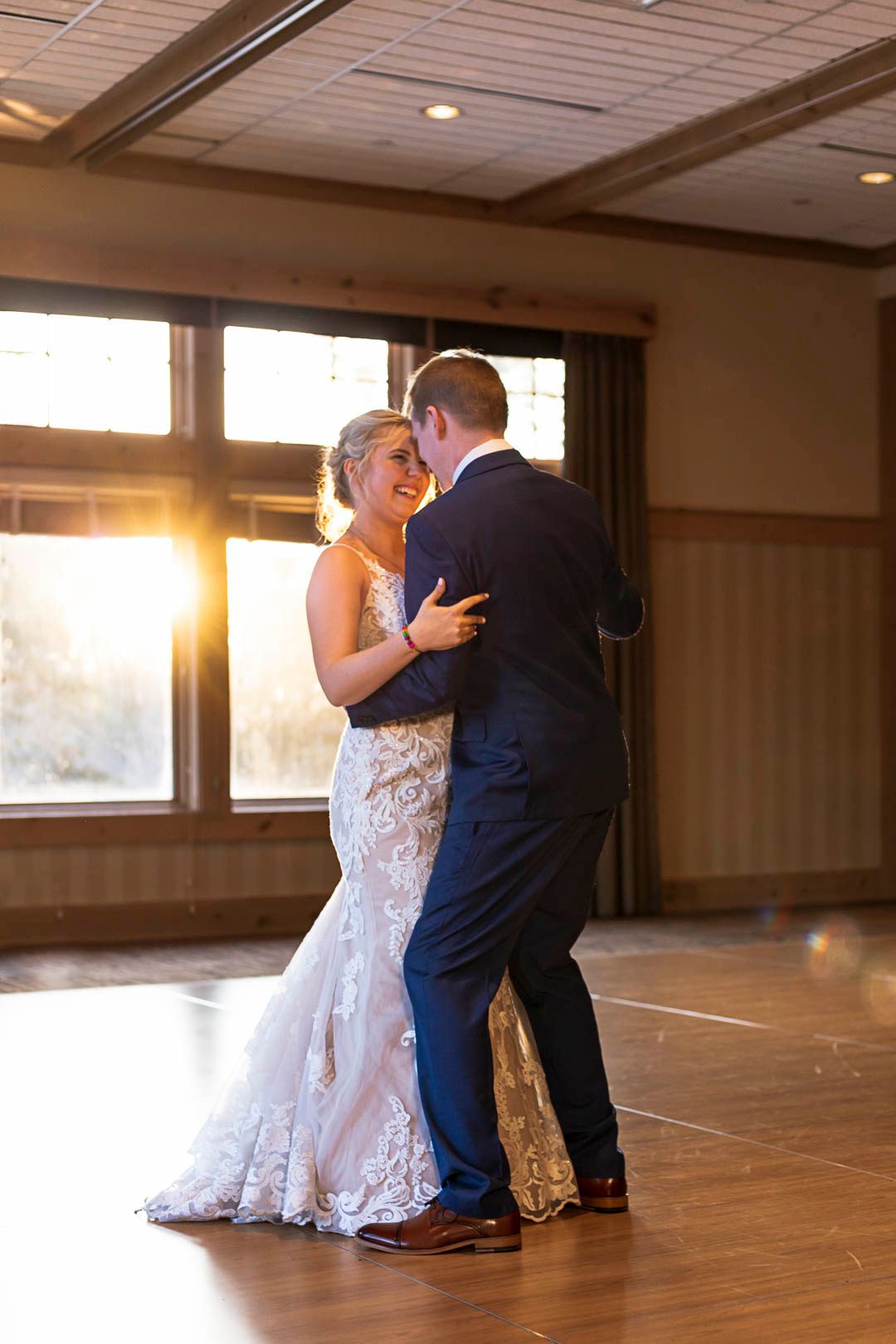 Bunker Hill Event Center Sunset peeks through as couple dances to their first dance with the icy sunset peeking in windo