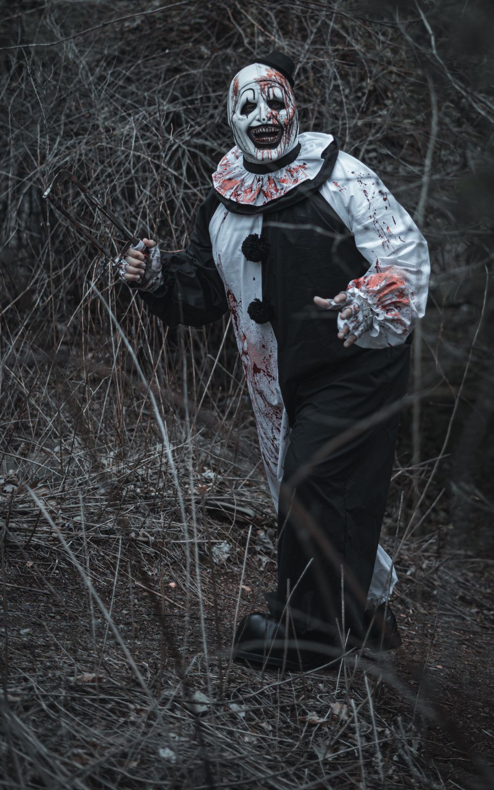 Art the clown coming out of the woods all bloody looking towards the camera