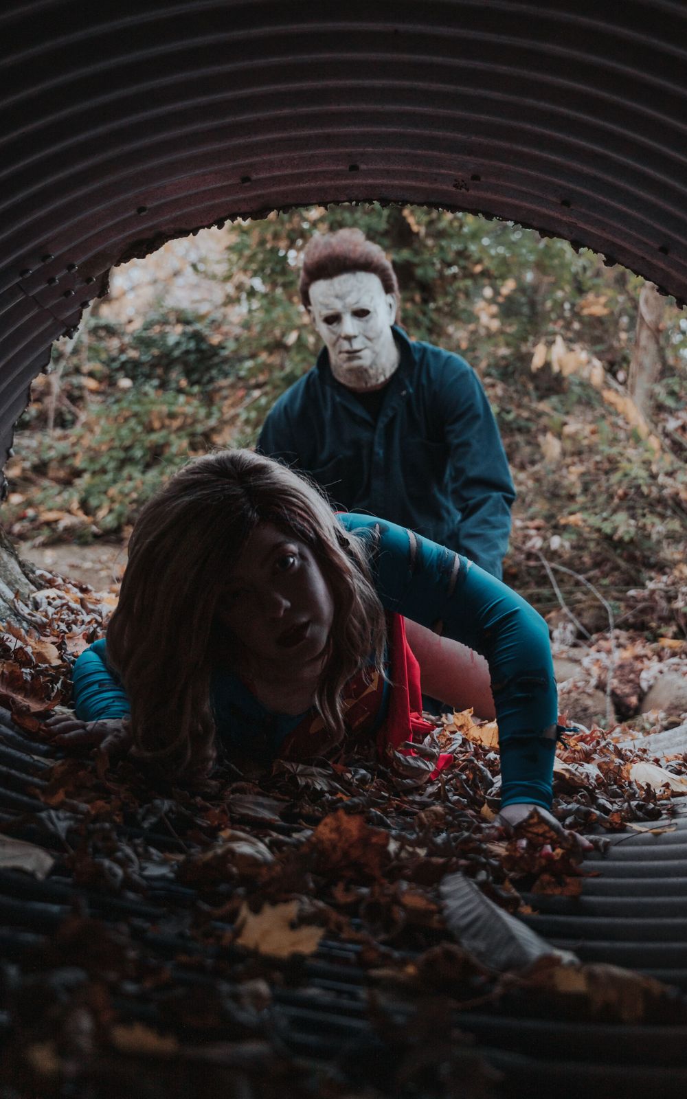 Supergirl trying to crawl away from Michael Myers in a tube.