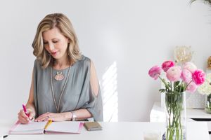 Business woman writing in calendar in a white office