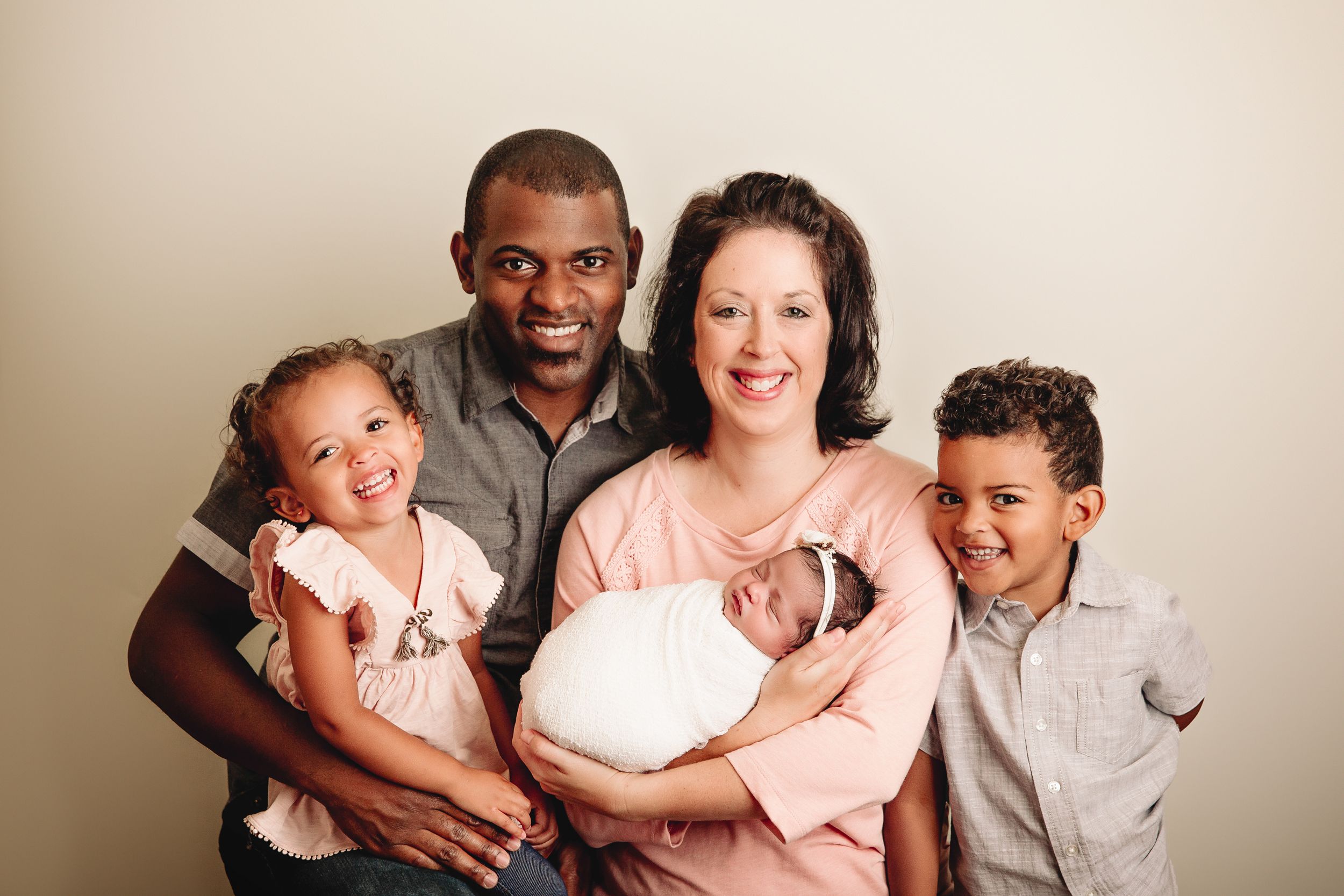 family posed in studio session on white background