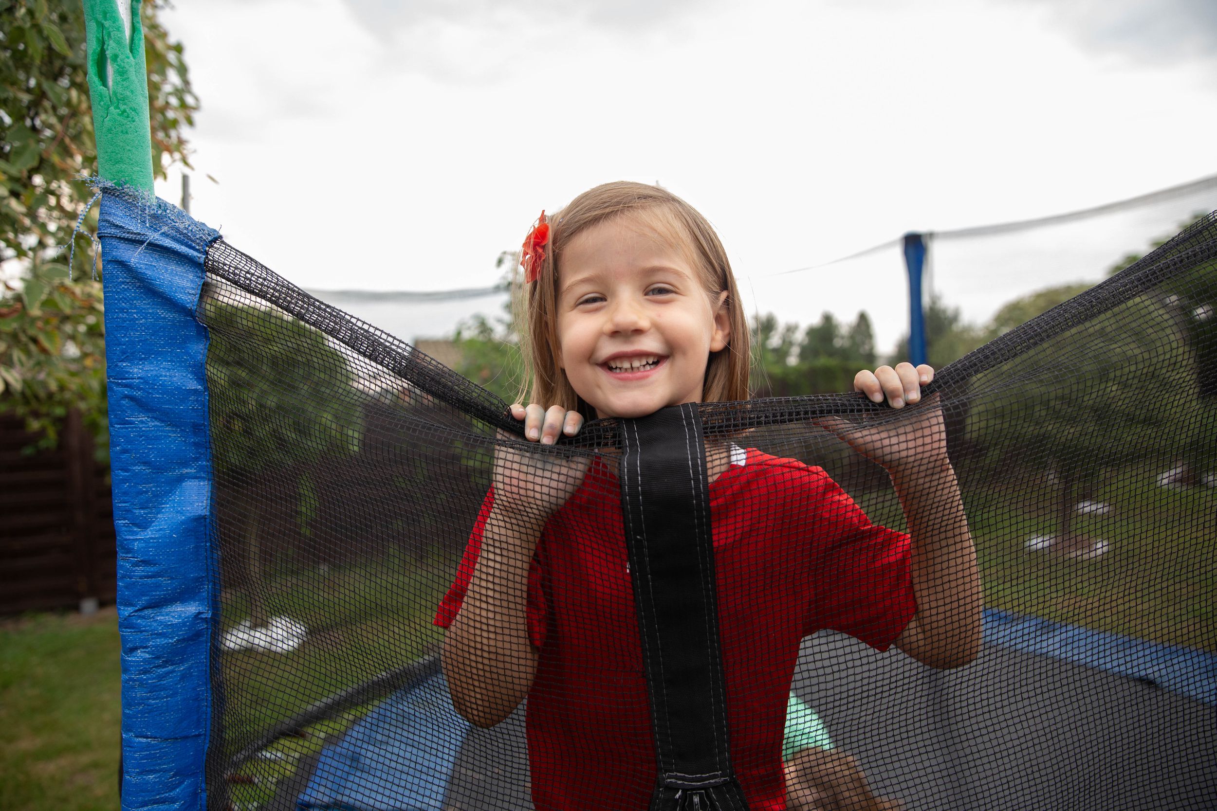 girl in red shirt jumping on trampoline