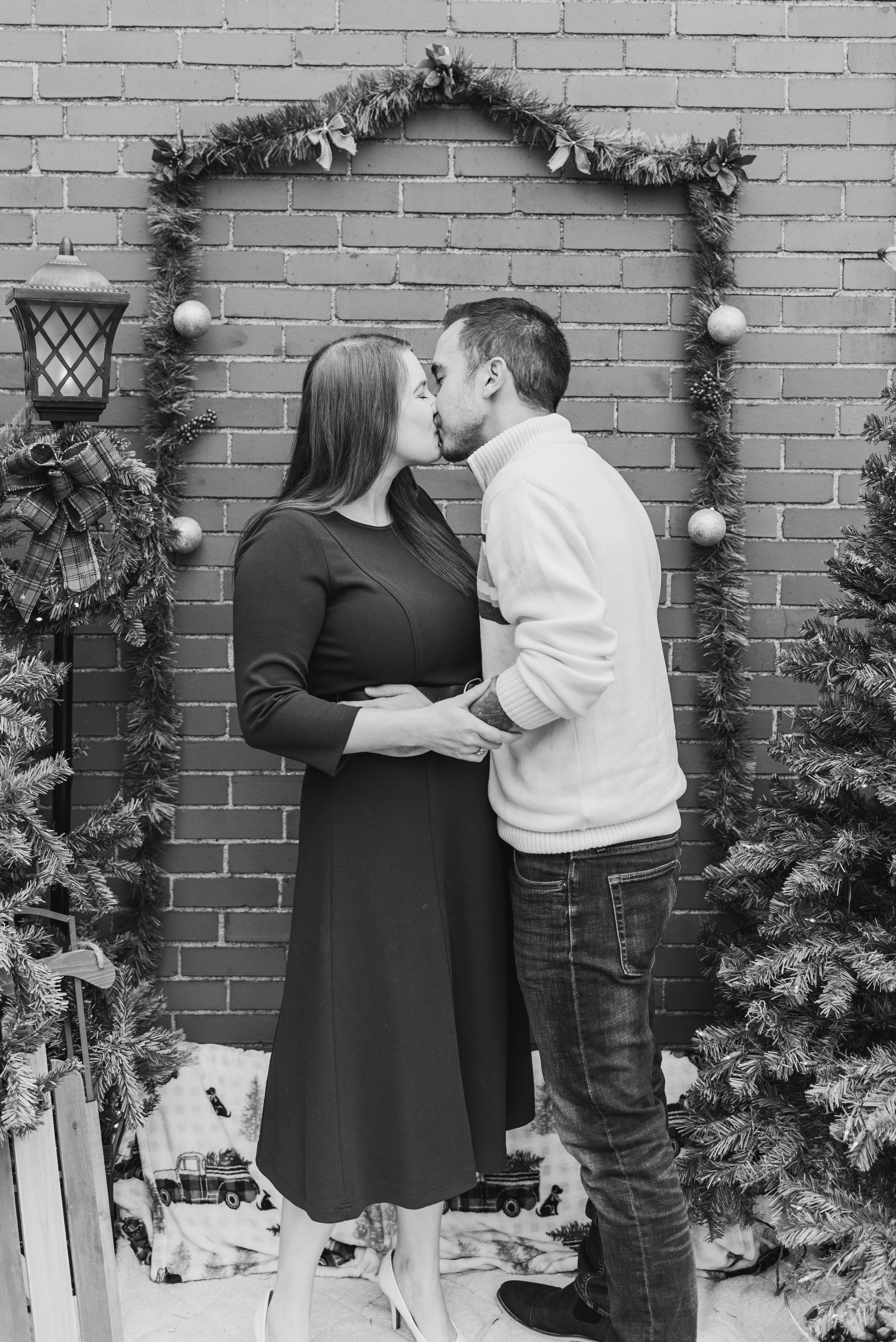 Couple kissing in black and white in holiday Christmas shoot with surprise proposal in Pittsburgh, Pennsylvania