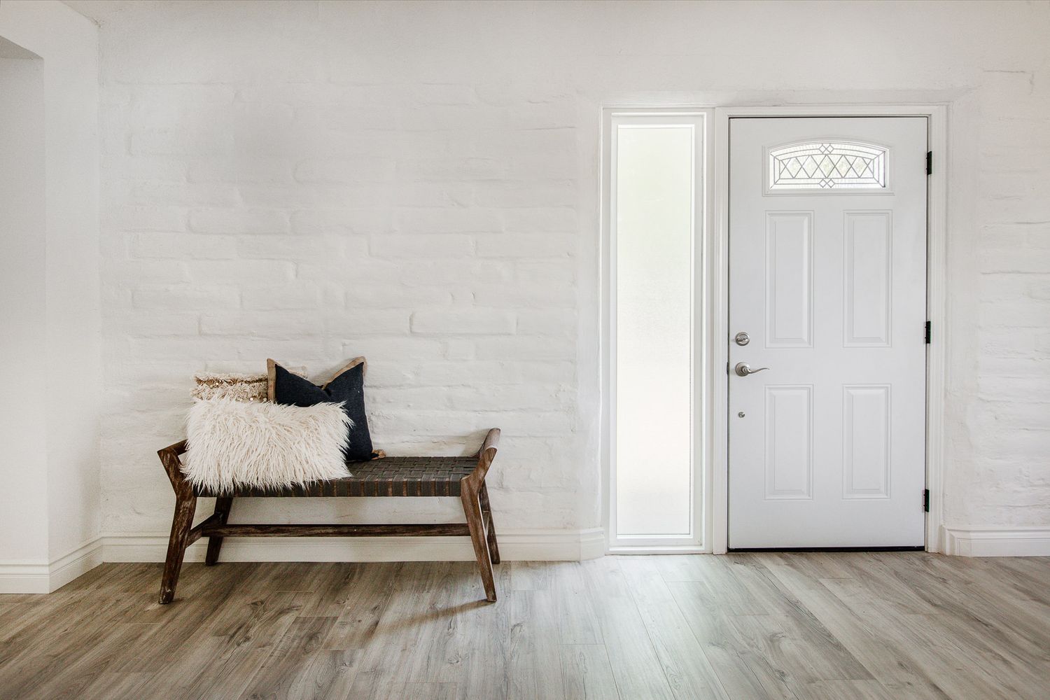 home staging - Minimal - bench with pillows agains a white wall. Get a quote from simply staging