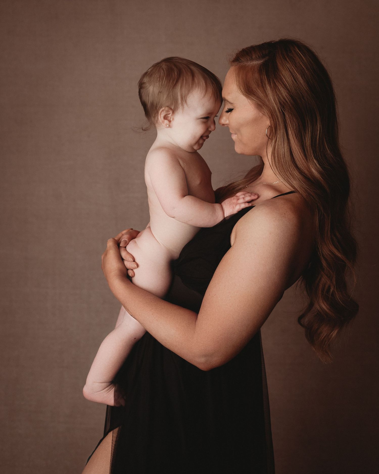 nose to nose mum a one year old posing motherhood studio black dress