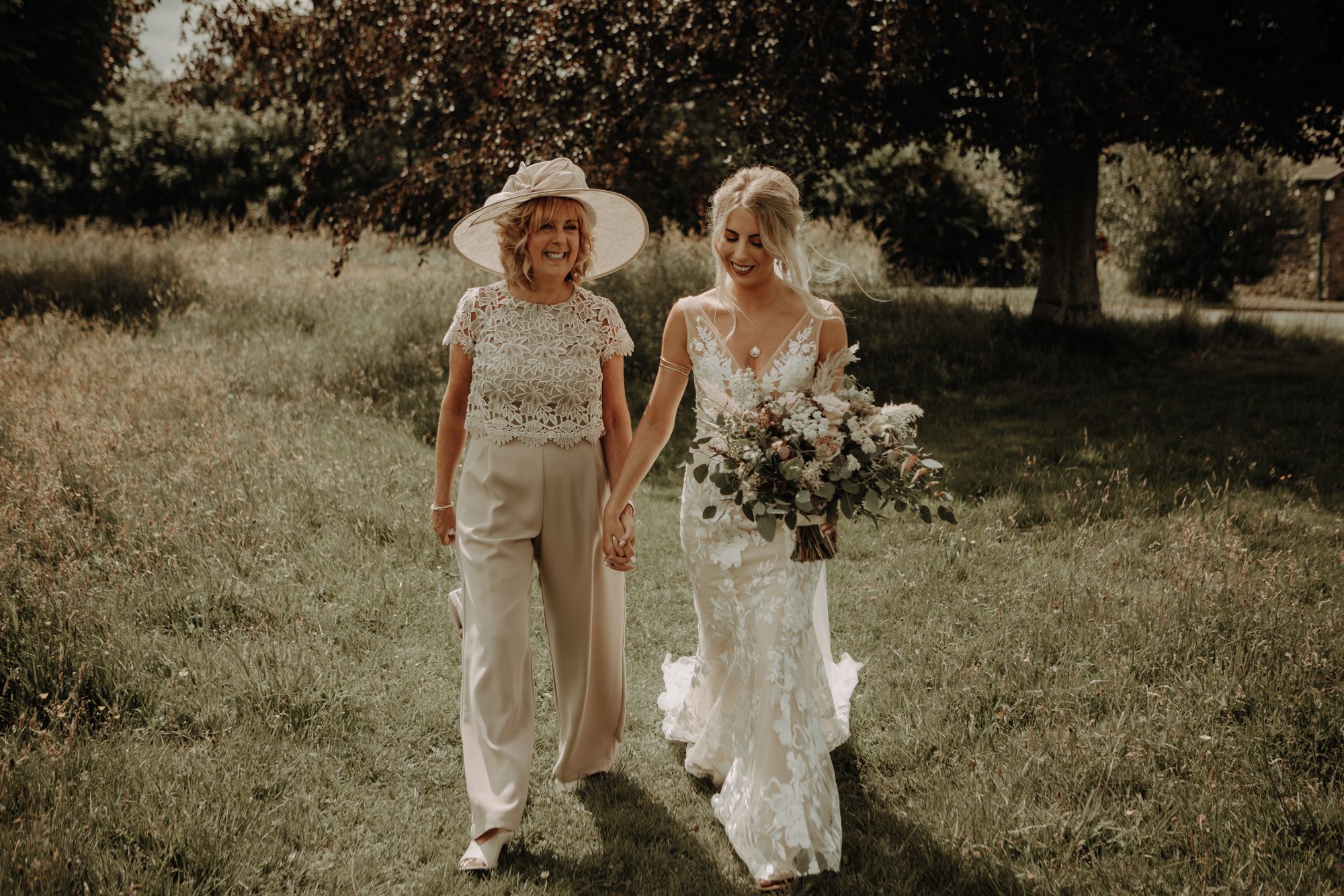 Mother of the Bride and bride, made with love gown and sassflower bouquet, cumbria wedding
