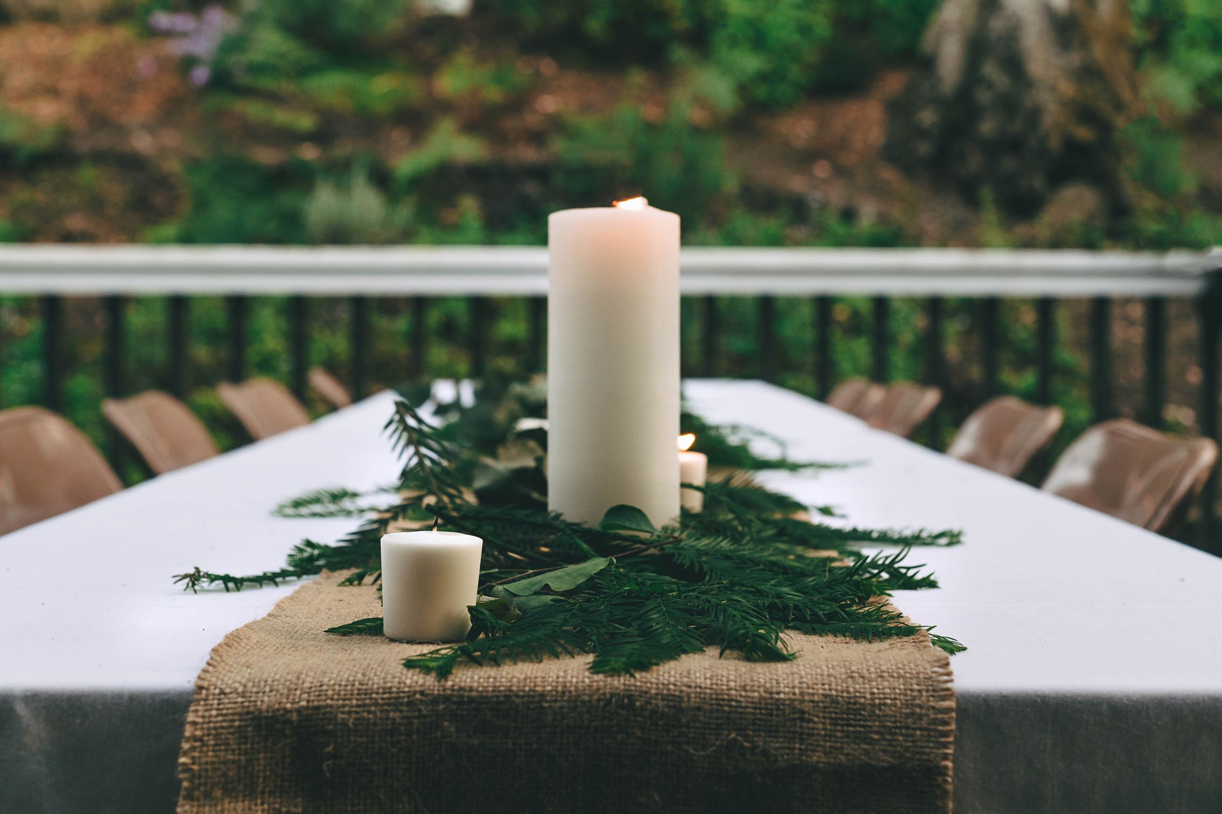 candle and redwood leaves on reception table