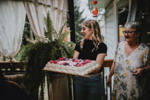girl in black shirt brining a birthday cake