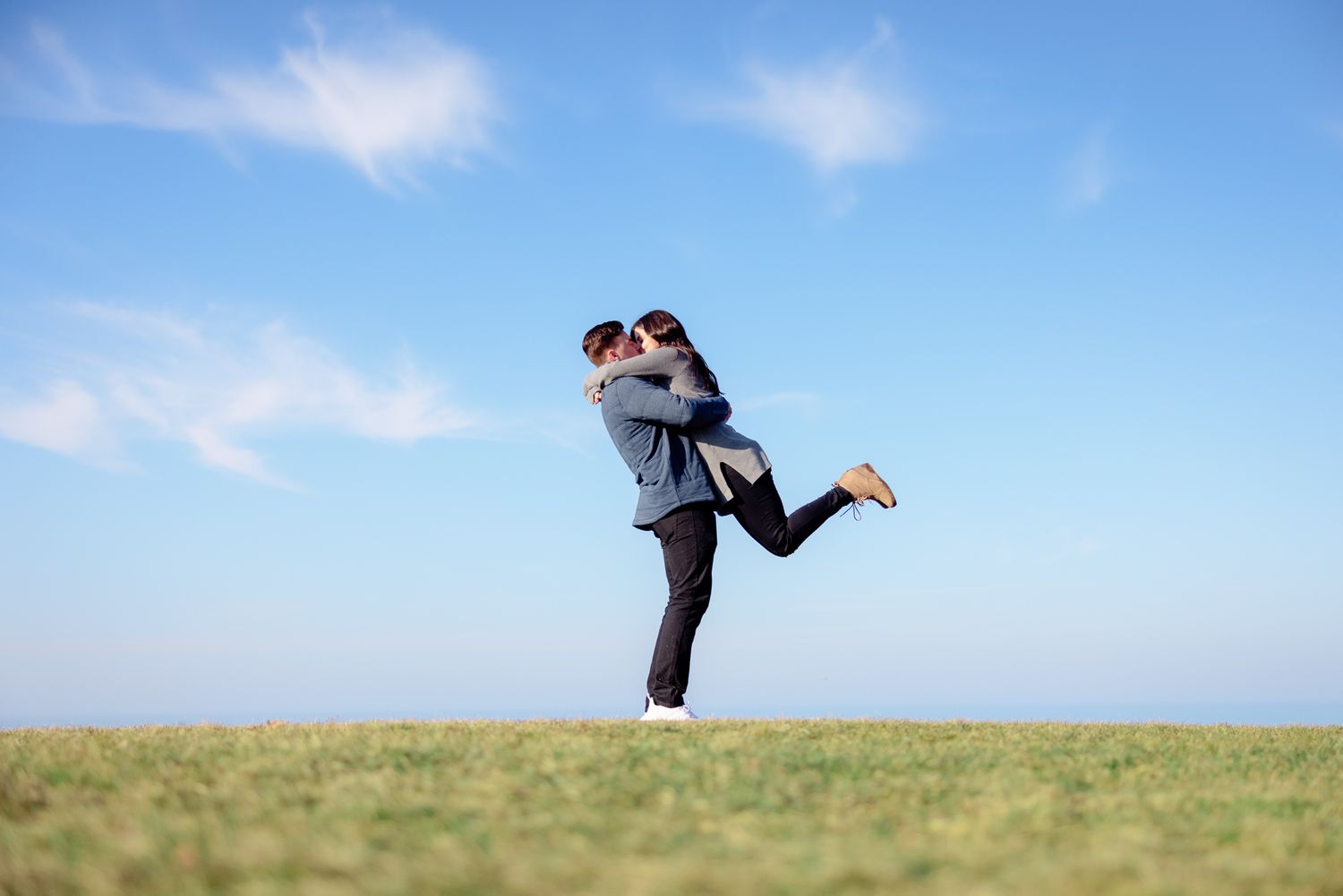 Young Engaged Couple Lifting During Spring Engagement Photo Session at Lakewood Park in Lakewood, Ohio