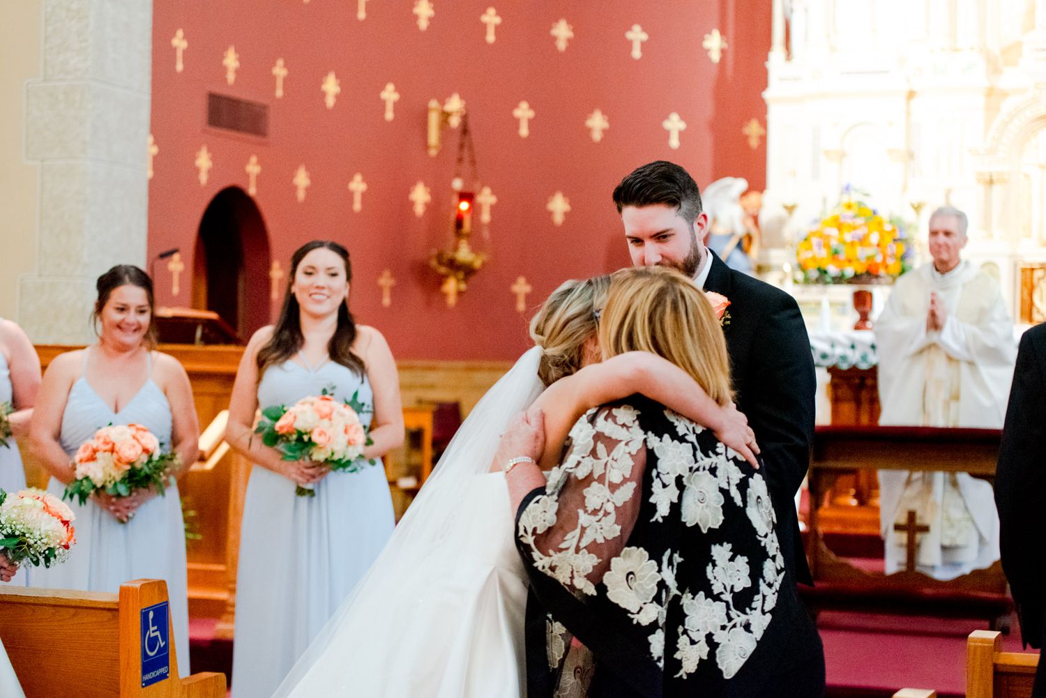 mother and bride hugging before handing bride off to groom