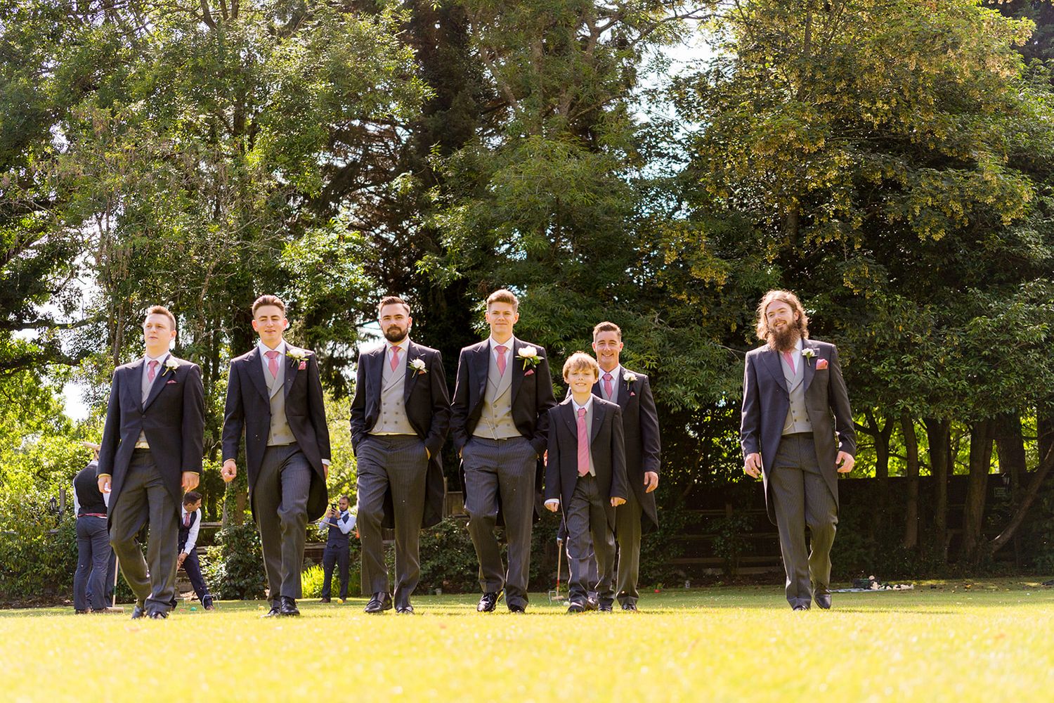 groomsmen walking in garden