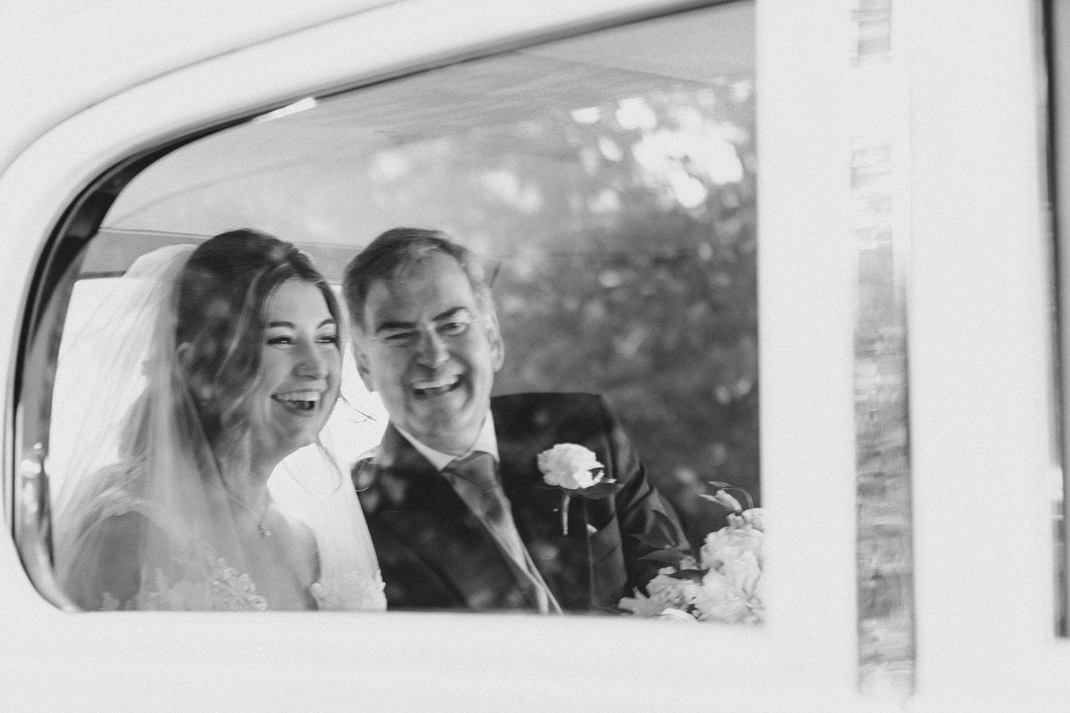 bride arriving in wedding car with her dad black and white