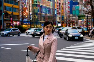 Young woman crossing a busy road in Tokyo Japan