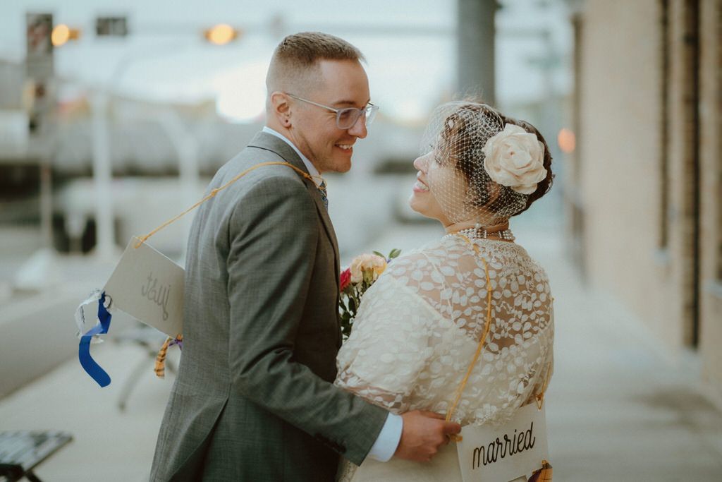 A couple shares a joyful moment together outdoors during their wedding celebration.
