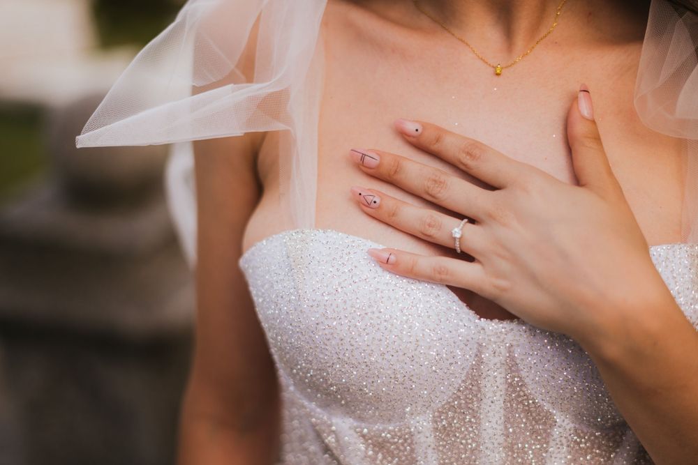 Close-up detail of a sparkling white wedding dress with delicate lace and tulle details.