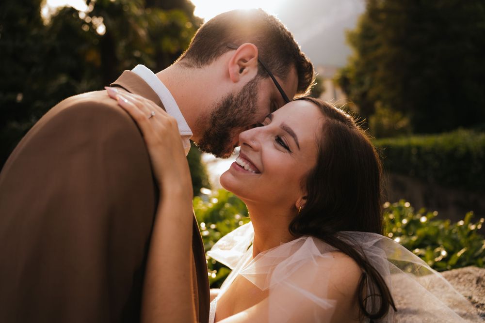 An intimate portrait of a couple sharing a tender moment in warm sunlight.