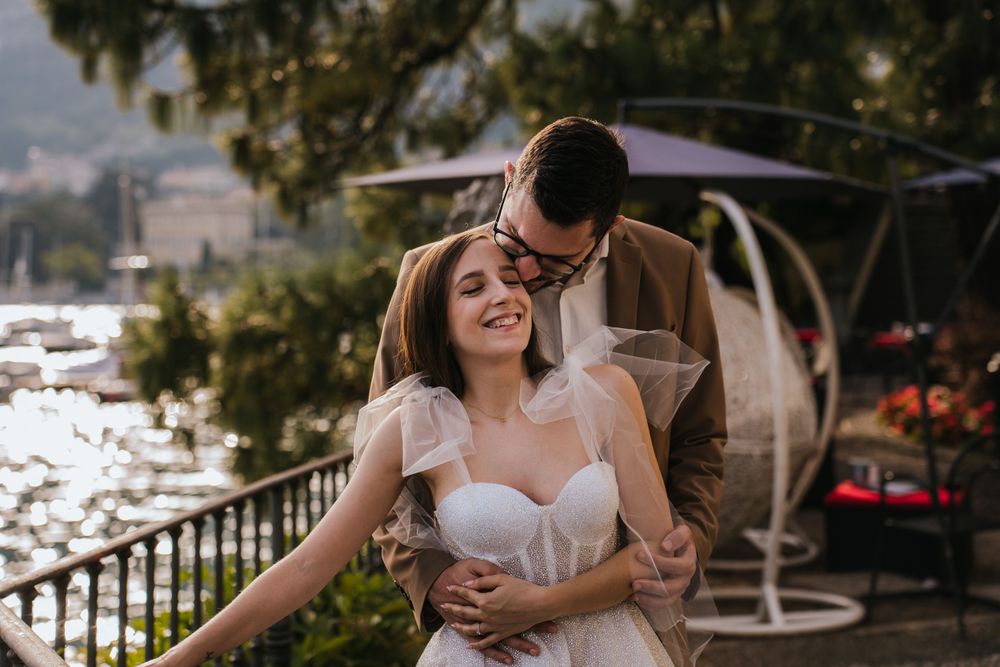 Couple dancing and embracing on a scenic overlook with mountains and water in the background.