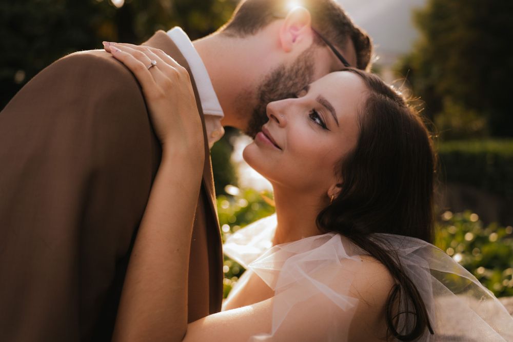 A romantic moment between a couple in formal wear captured in golden sunlight.