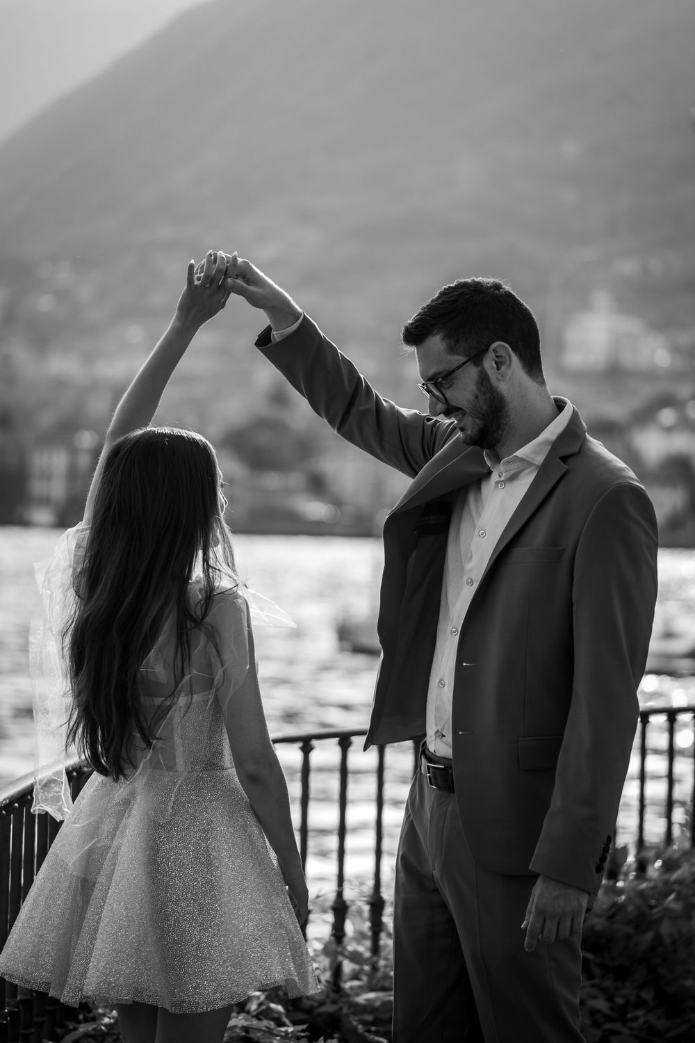Romantic dancing couple in black and white create dynamic movement against mountain backdrop.
