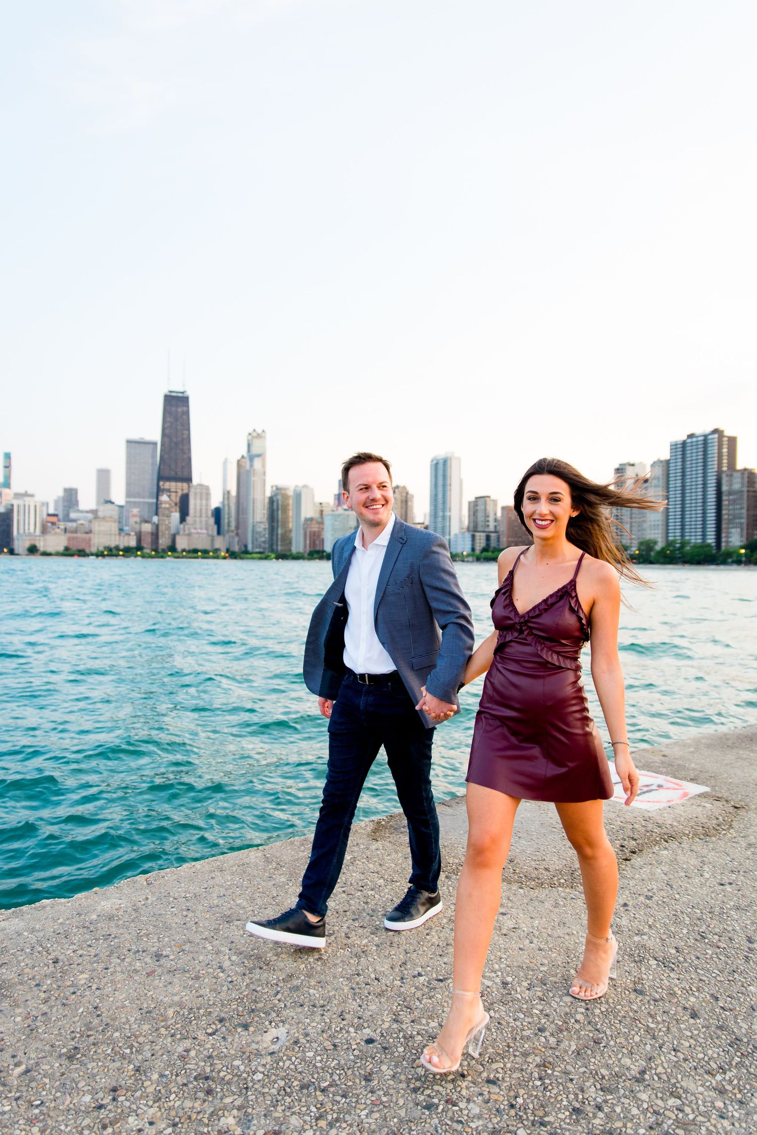 man and woman holding hands walking along pier at North Avenue Beach Chicago