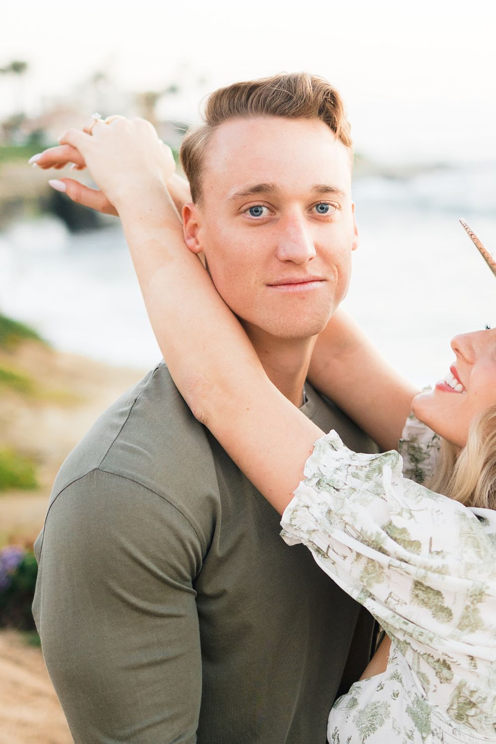 A playful coastal portrait session with a couple enjoying sunset by the ocean.