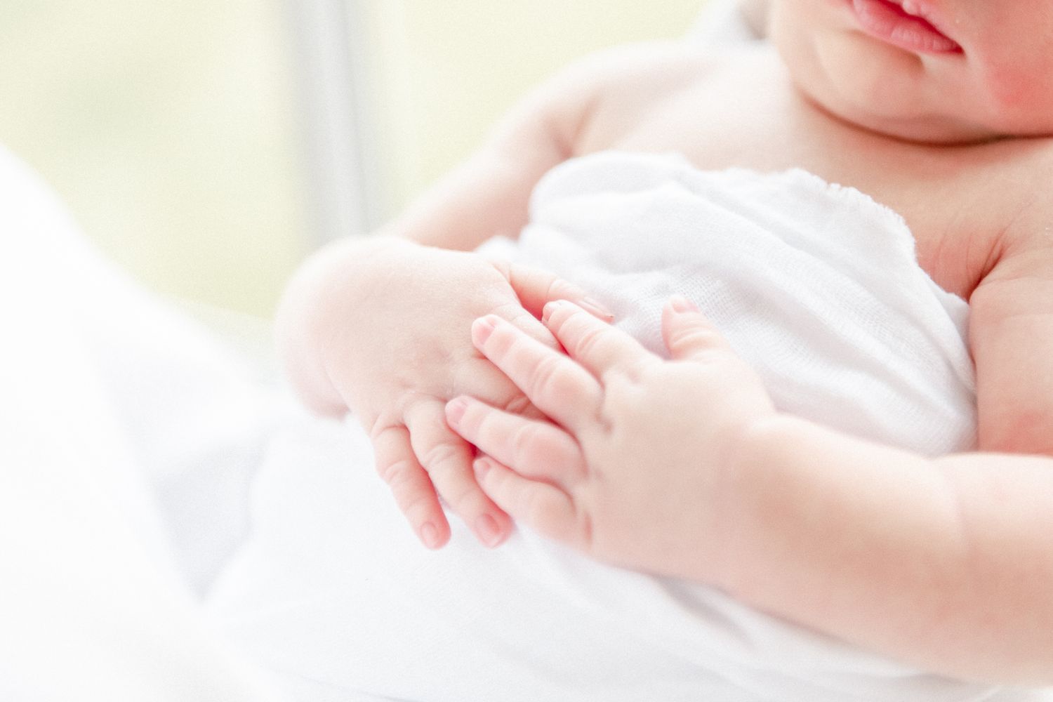 Newborn hands with interlocked fingers