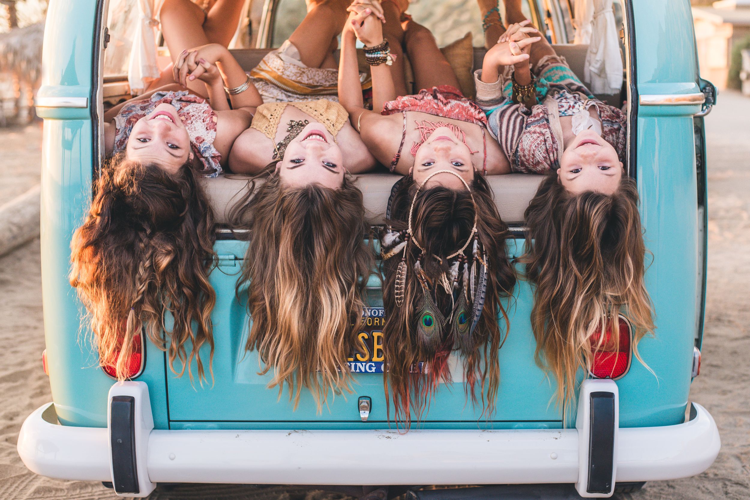 Teen girls in Volkswagen Bus on the beach in Dana Point, CA