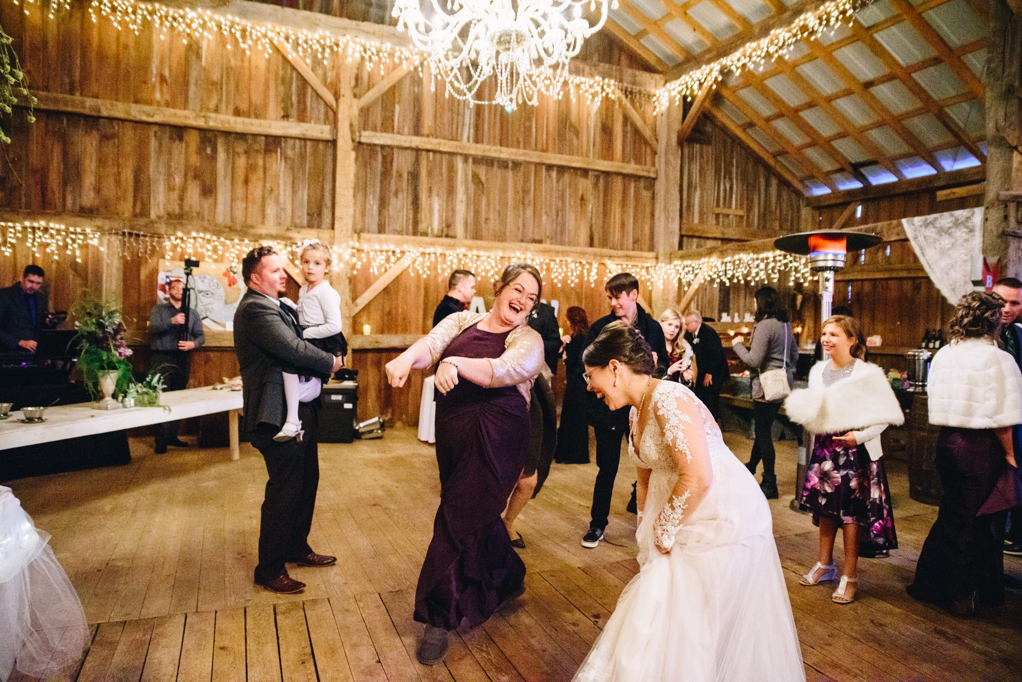 bride laughing while bridesmaids dances at wedding reception at the Sheperd's Place wedding