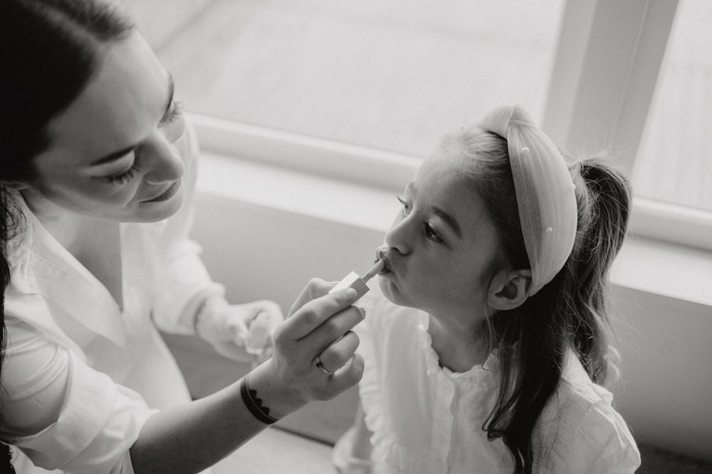 A gentle makeup application moment captured in black and white photography.