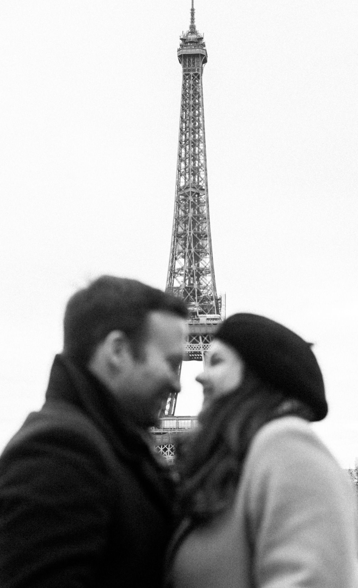 Intimate black and white portrait with the Eiffel Tower towering in the background.
