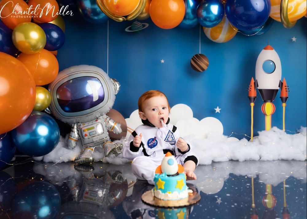 Baby boy dressed as astronaut eating cake