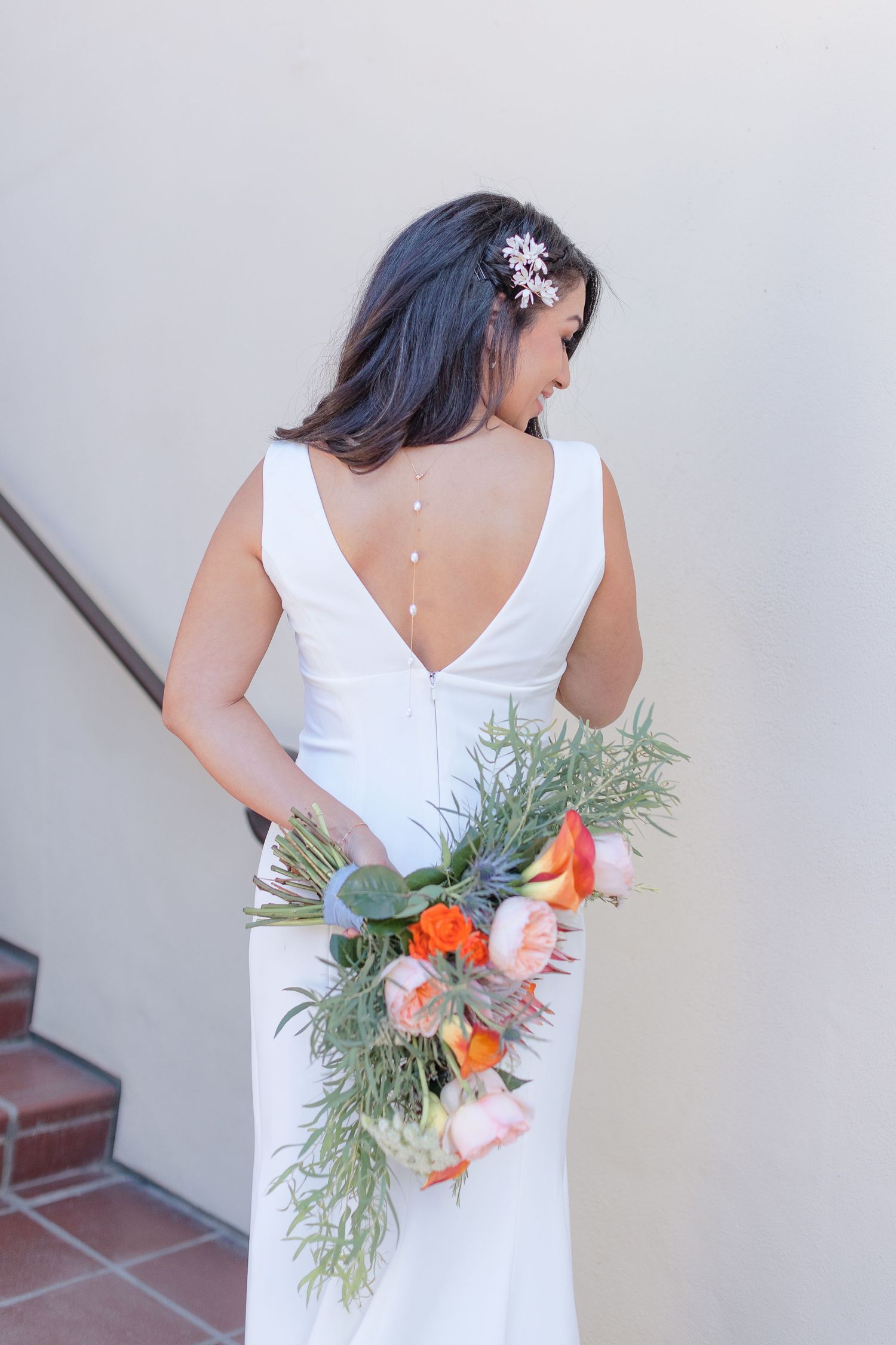 back of wedding dress with bouquet pose