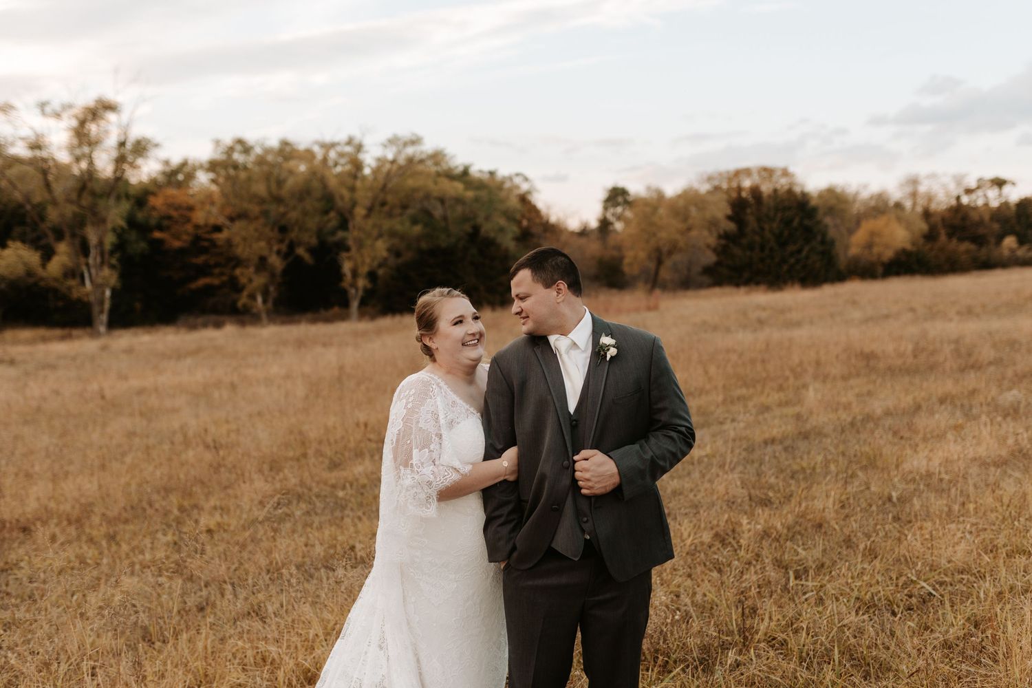 A romantic wedding portrait captured in a golden autumn field.