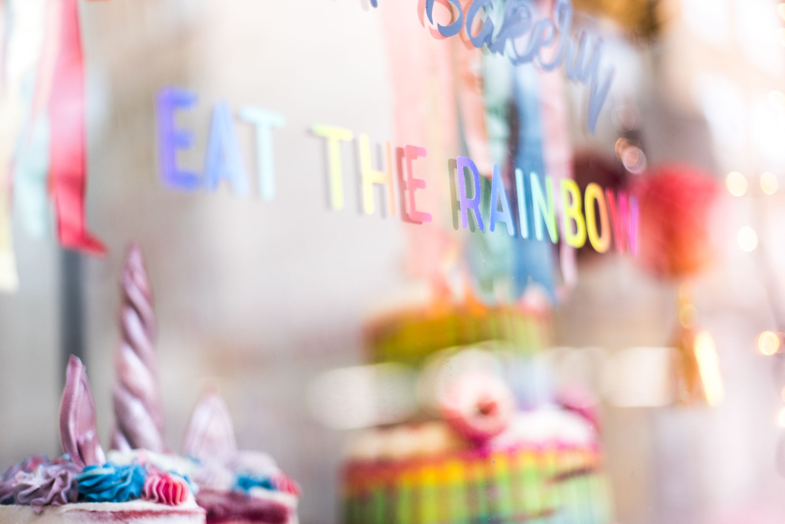Colorful bakery window with rainbow reference