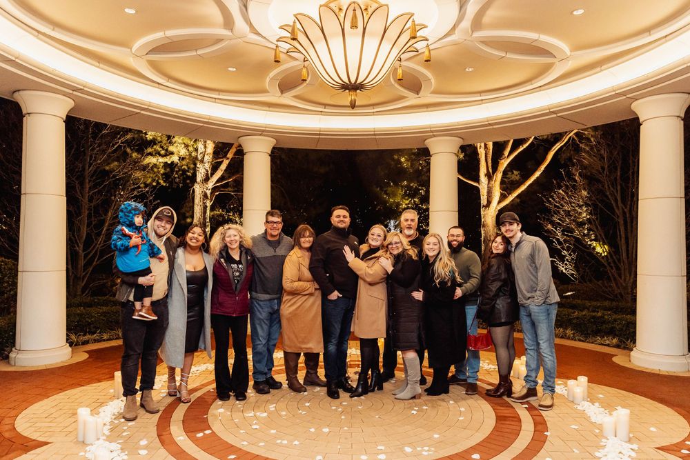 Group photo of celebration attendees gathered in illuminated outdoor rotunda.