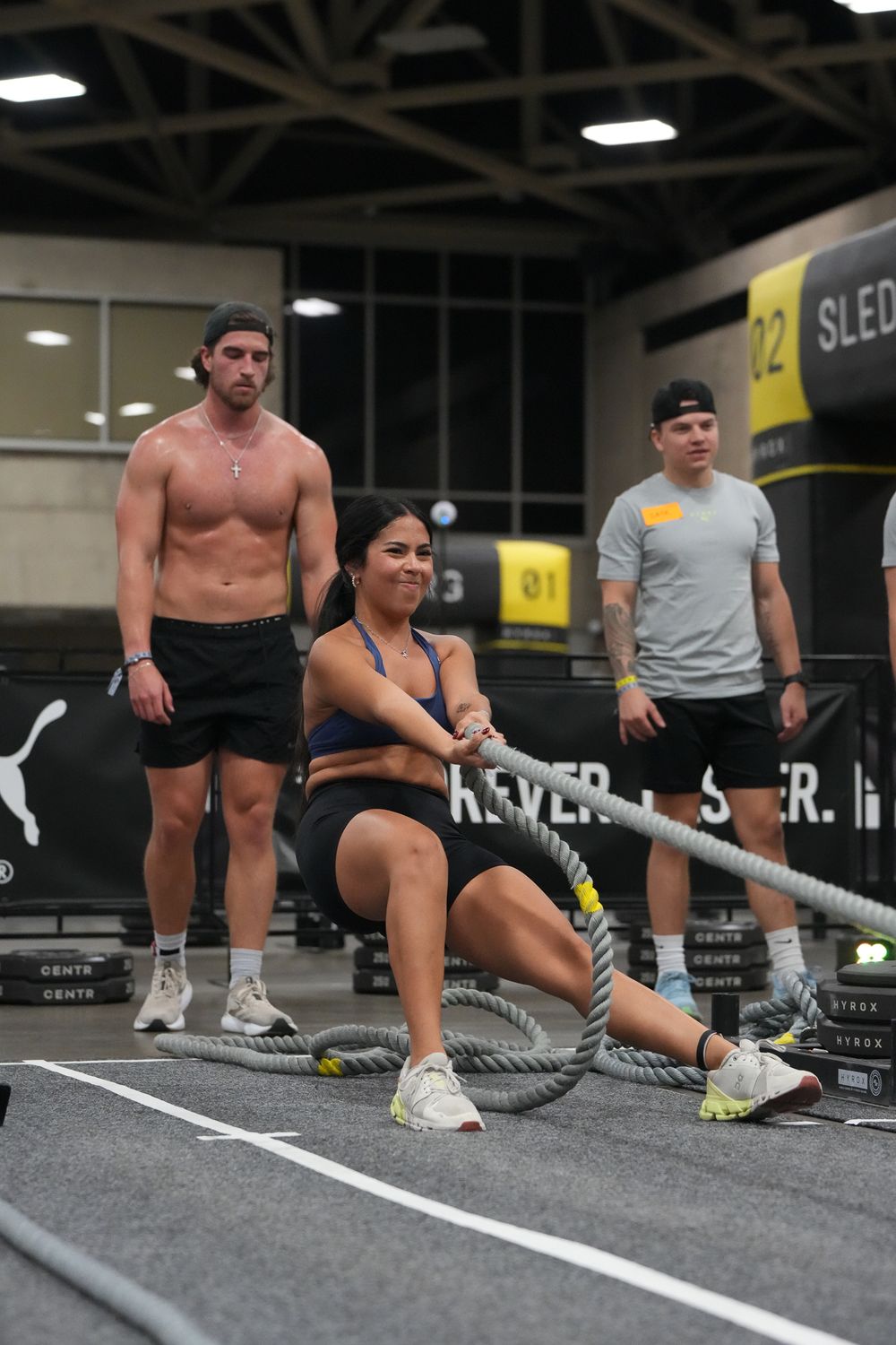 Athletes training with ropes during indoor fitness competition.