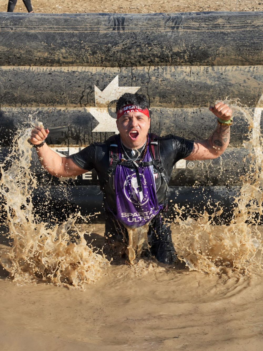 Participant overcoming a challenging obstacle at the Spartan Race in Dallas, Texas, showcasing strength.