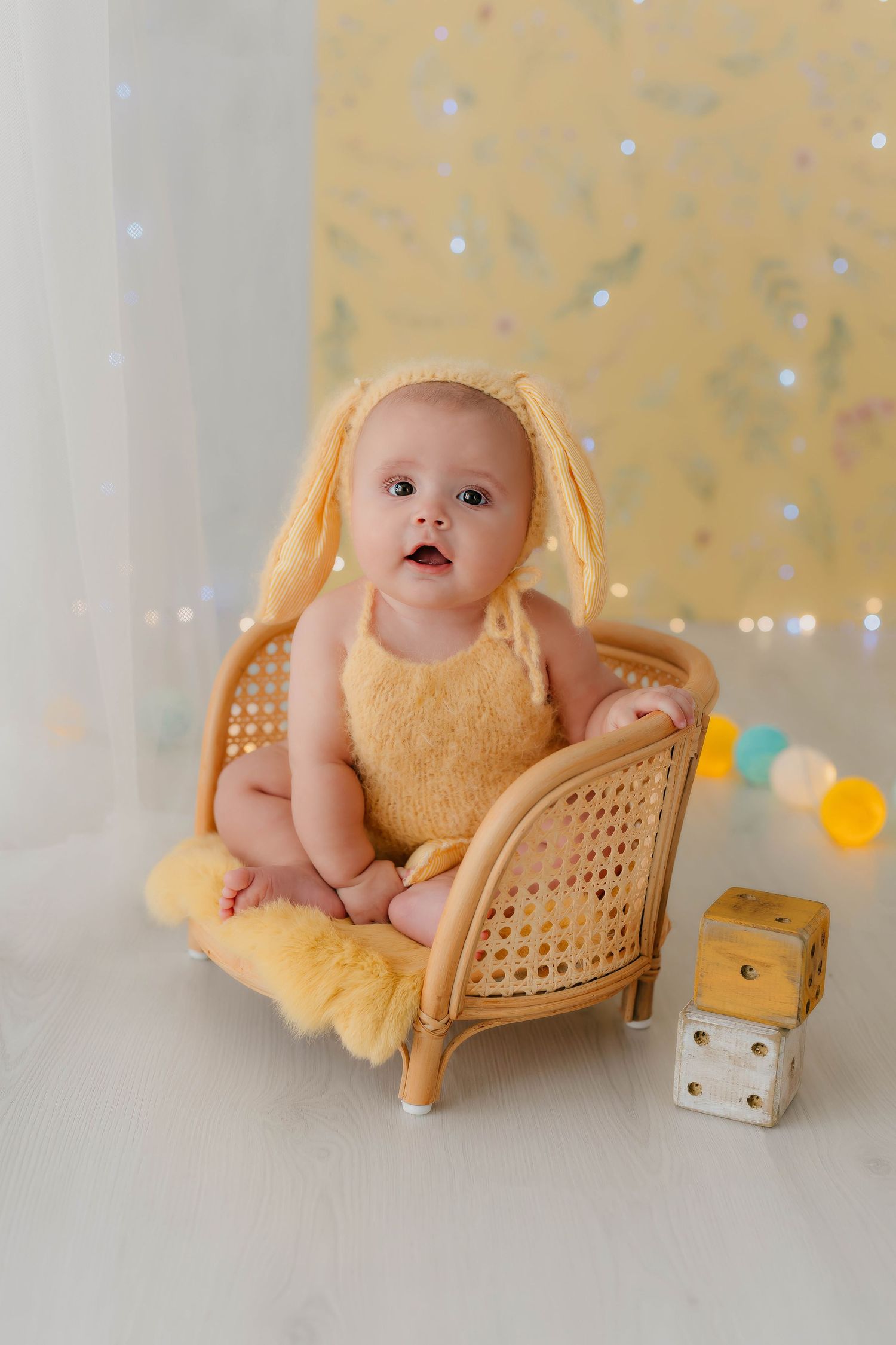 Niña de seis meses vestida de conejita en tonos amarillos en una sesión fotográfica de seguimiento.