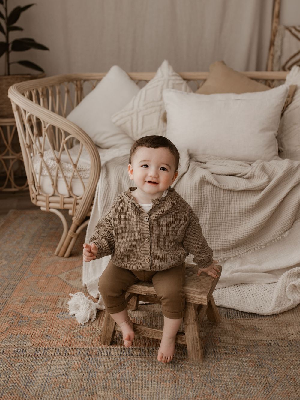 Happy moments captured on wooden chair with neutral decor and blankets.