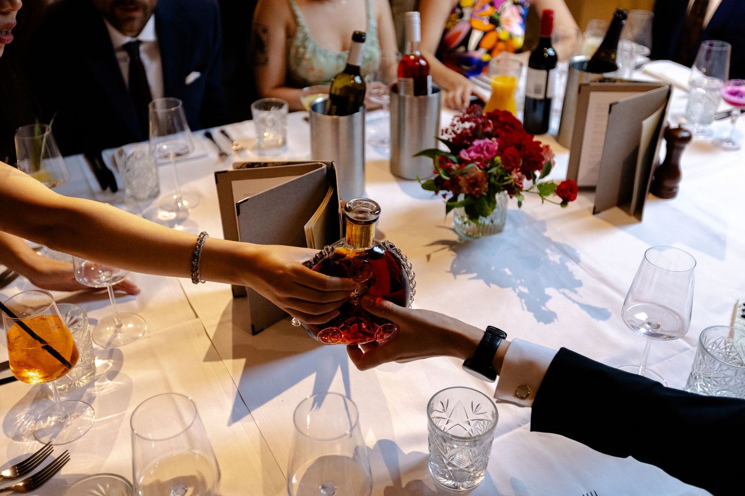 Elegantly set wedding table with wine glasses, place settings and floral centerpieces.