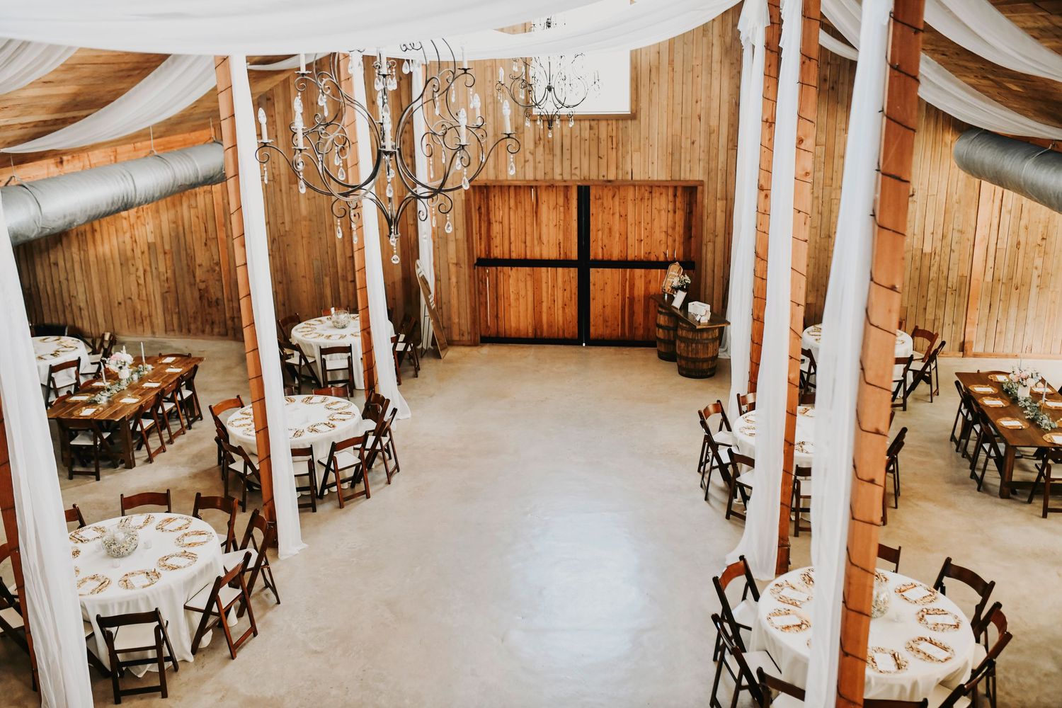 Reception barn with string lights and terracotta-toned floral centerpieces