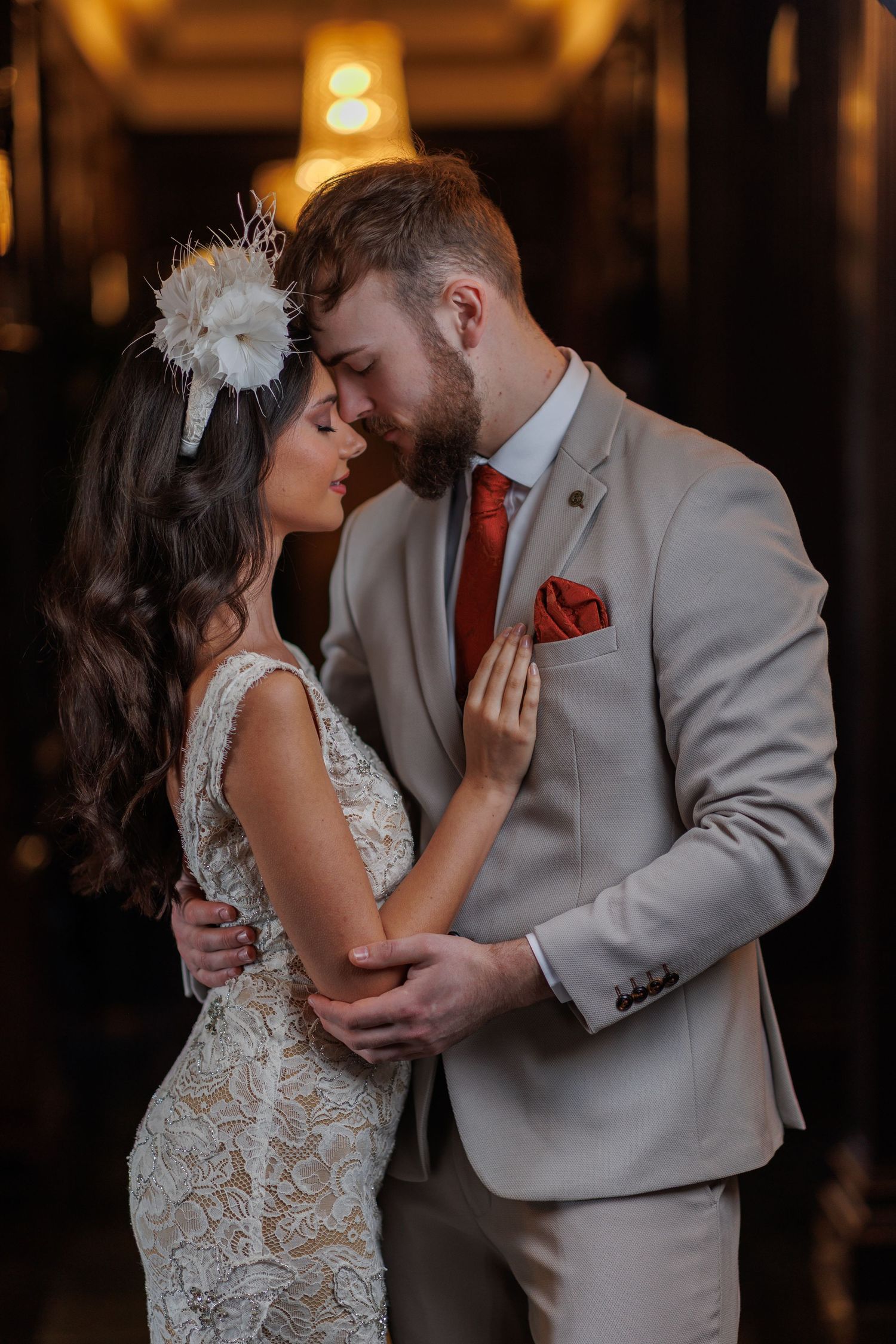 Intimate indoor wedding portrait with warm ambient lighting.
